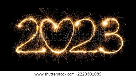 Sparkling burning creative numeral 2023 with heart isolated on black background. Design element for New Year 2023. Beautiful Template for design greeting card, holiday flyer, billboard or Web banner Royalty-Free Stock Photo #2220301085