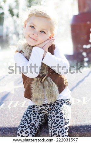 Little girl near fountain, autumn time