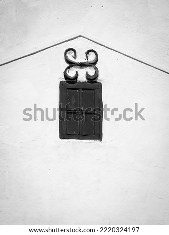 minimalist photo of small classic window with decoration on building wall