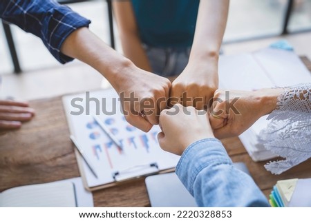 Group of young businessmen in Asian suits clasping hands Stack your hands to brainstorm to complete tasks on a given project. Passionate and excited about their work, and success concept. Royalty-Free Stock Photo #2220328853