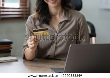 Young woman holding credit card. Businesswoman working at home. Online shopping, e-commerce, internet banking, spending money, working from home concept