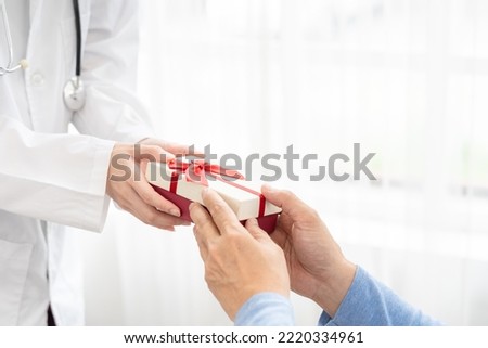 Doctor to senior old elderly people. Medical health care. senior's hand receives a gift box from doctor.