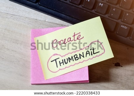 Sticky note with the memo Create Thumbnail on desk by the keyboard.  Royalty-Free Stock Photo #2220338433