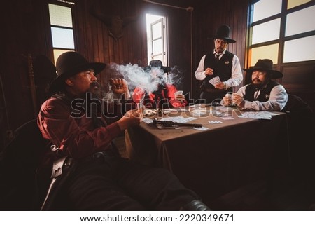 Cowboys group playing poker and card  gambler game in old American west saloon is cowboy vintage life stayle.