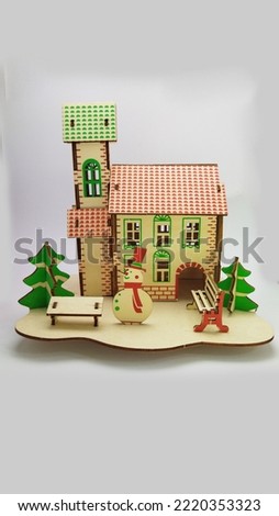 
wooden puzzle shaped christmas house complete with snowman