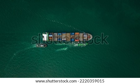 Container ship carrying container for import and export international in green sea aerial top view photograph from drone