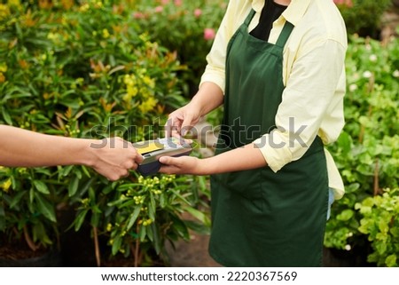 Customer paying for plants at gardening center with credit card Royalty-Free Stock Photo #2220367569