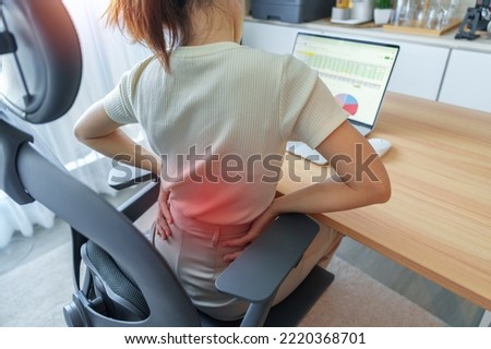 Woman having back body pain during work long time on workplace. due to Piriformis, Low Back, waist ache, lumbago, kidney, rheumatism and Spinal Compression. Office syndrome and Ergonomic concept Royalty-Free Stock Photo #2220368701