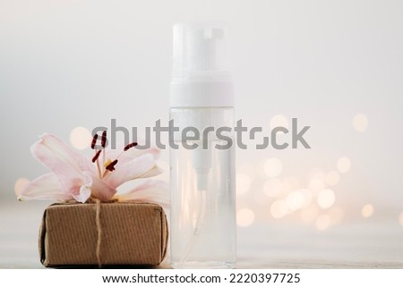 Beauty products bottles with present box and flowers. Holiday gift cosmetic concept