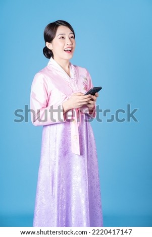 Image of young Korean woman wearing hanbok on background Royalty-Free Stock Photo #2220417147