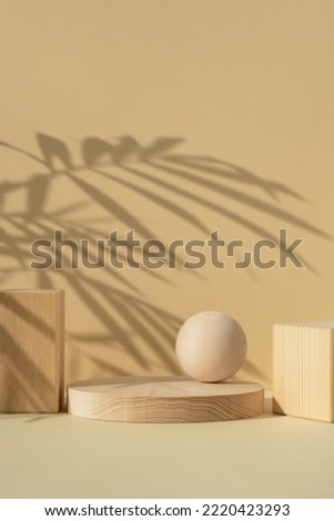 Wooden scenes of different geometric shapes with a shadow of tropical palm leaves on a beige background. Premium podium for advertising your product. Showcase, display case.