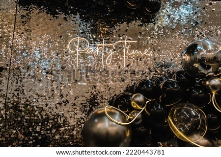 Text party time. Happy New Year 2023. Photo booth was decorated black and silver balloons and led strips. Zone with decor sparkling sequins for wedding. A place for congratulations for birthday.