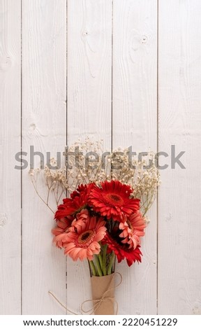 Happy birthday. Red gerbera daisy flowers on white wooden table, flat lay