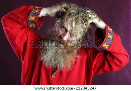close-up portrait of the blessed with a long beard and a mustache and wet blond hair in a red shirt studio