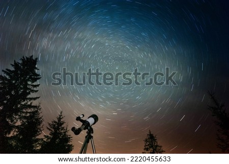 Modern telescope under night sky with star trails outdoors, low angle view. Learning astronomy Royalty-Free Stock Photo #2220455633