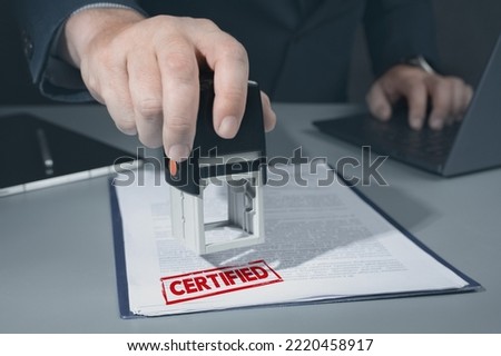 certified stamp on document. businessman approve and certificate concept, confirmation of business marketing document permit and certified stamping. Person Hand Stamping With certified Stamp Royalty-Free Stock Photo #2220458917