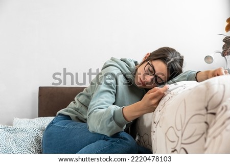 Young frustrated sick woman ill from common cold and flu virus measuring her body temperature, feeling miserable and weak. Business woman cant go to the work due to sickness. Royalty-Free Stock Photo #2220478103
