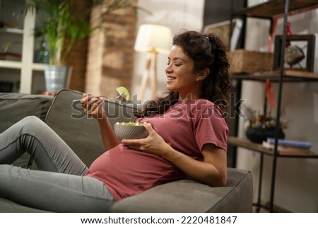 Pregnant woman eating fuit at home. Beautiful pregnant woman enjoy in healthy meal