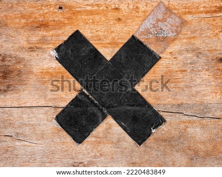 "X" sign on wood made of black sole