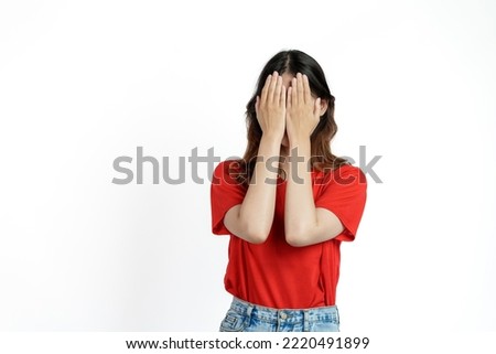 Happy pretty young asian woman red t-shirt isolated white background. close your eyes