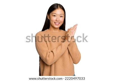 Young Asian woman isolated on green chroma background feeling energetic and comfortable, rubbing hands confident. Royalty-Free Stock Photo #2220497033