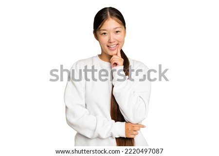 Young Asian woman isolated on green chroma background smiling happy and confident, touching chin with hand.