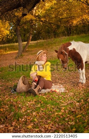Beautiful picture, autumn nature, woman and horse, concept of love, friendship and care. background.