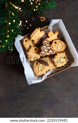 Different shape butter cookies into the box on concrete backgroudn with fur bruch and golden boke. Christmas treat .Copy space