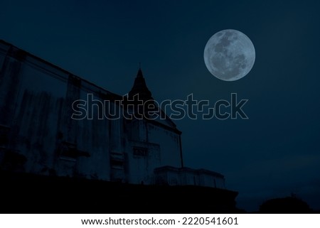 Full moon with temple silhouette in the dark night.