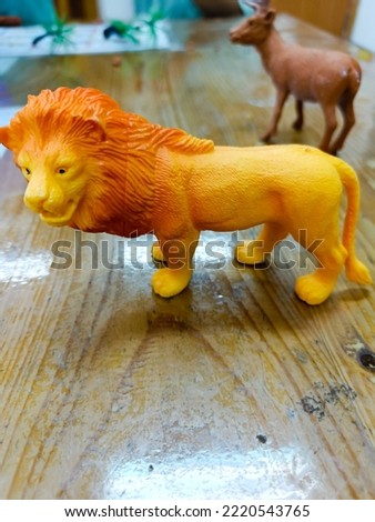 The animal figure of a lion on the wooden table.
