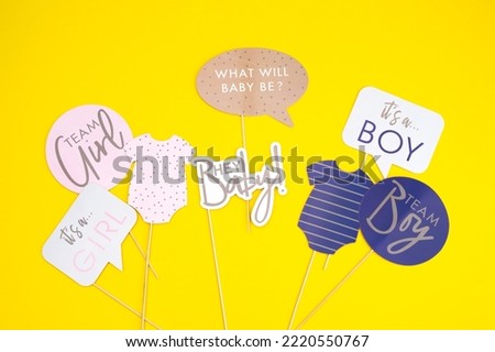Background of the day of gender reveal party. Invitation card, party supplies, birthday whistles, party glasses and hats, gift boxes, flags and napkins.