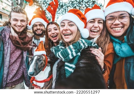 Self portrait of race young people wearing santa claus hat celebrating Christmas day outside - Happy multiracial friends group taking selfie having xmas holiday party - Winter holidays concept