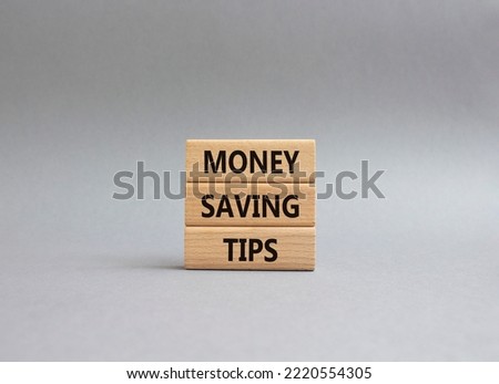 Money saving tips symbol. Concept words Money saving tips on wooden blocks. Beautiful grey background. Business and Money saving tips concept. Copy space.