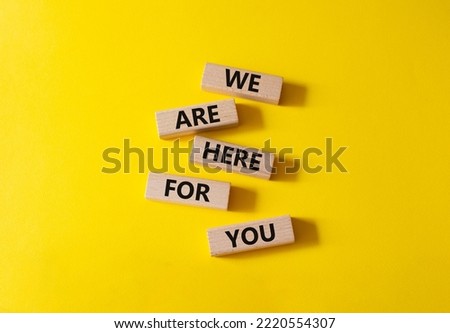 Help symbol. Wooden blocks with words We are here for you. Beautiful yellow background. Business and We are here for you concept. Copy space.