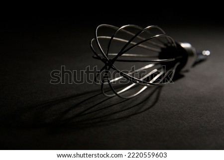 A steel stirrer with shadow in a dark space.