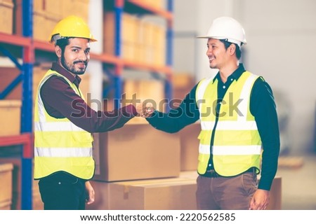 Male workers fist bump in vintage tone. Hands of factory warehouse worker people show strength teamwork in logistics industrial background. Team of factory workers working in logistic business.