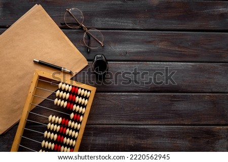 Accounting wooden abacus with blank sheet of paper. Financial calculations concept