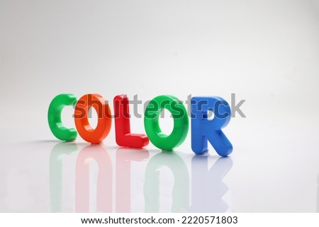 red green blue yellow plastic toy capital font letter alphabet color on white background copy text space concept 
