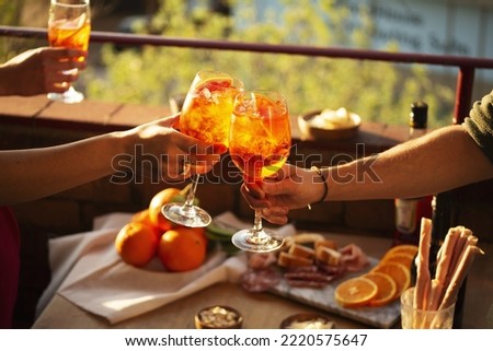 Two hands with glasses of Aperol spritz cocktail Royalty-Free Stock Photo #2220575647