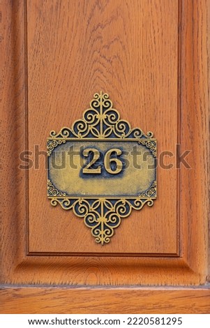 Engraved Number Twenty Six at Wooden Door