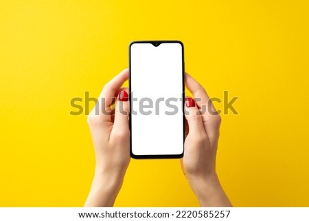 Cyber monday concept. First person top view photo of woman's hands holding smartphone on isolated yellow background with blank space