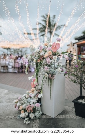 Romantic wedding party with stage on pool area. pale Blue white pink purple flowers accent. Modern wedding decoration, table settings outdoors for intimacy wedding dinner with family and friends on to