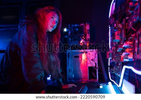 Program or cyber security development concept. Young woman working with monitors and checking system safety from cyber attack, hacker, programmer online error. work at night.