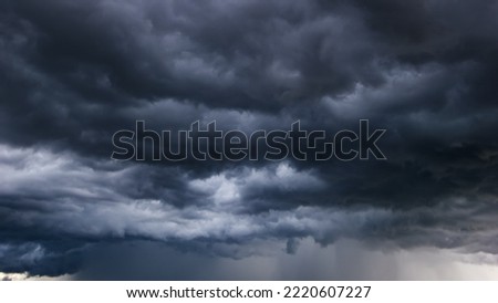 The dark sky with heavy clouds converging and a violent storm before the rain.Bad or moody weather sky and environment. carbon dioxide emissions, greenhouse effect, global warming, climate change Royalty-Free Stock Photo #2220607227