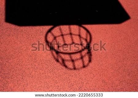 basket hoop shadow on the red playground