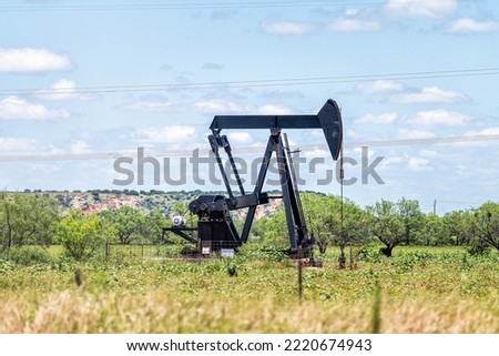 Sweetwater, Texas oil pumpjack on Oilfields in prairies with metal machine in field on sunny summer day with blue sky and nobody in landscape
