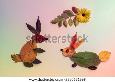 rabbit made from colorful leaves and bright flowers on pastel colored background