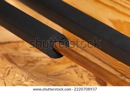 Water pipe with insulation in house. Plumbing freezing protection, energy savings and home repair concept Royalty-Free Stock Photo #2220708937