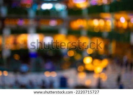 Blur and texture of light in a shopping mall, silhouettes of people and multicolored highlights.