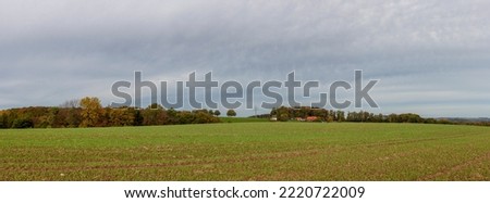 Lonely village house in the middle of a huge green field Panoramic rural autumn landscape in North Rhine Westphalia in Germany.